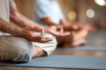 Obraz premium Close-up of hands in a meditation mudra pose during group yoga or meditation session.