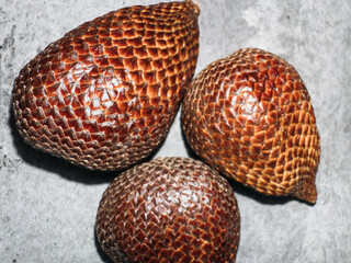 Snake fruit (salak) with scaly brown skin resembling reptile texture, exotic tropical fruit known for its unique appearance and sweet-sour flavor