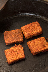 Tempeh Blocks of Fermented Soybeans in Cast Iron Pan for Vegan Cooking