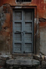 Vintage blue wooden door and window on an aged stone wall in an old house