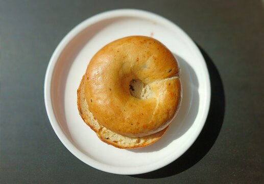 Freshly Baked Bagel Served on a White Plate - Powered by Adobe