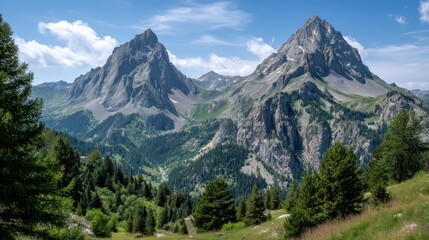 Obraz premium Majestic Mountain Peaks Surrounded by Lush Green Forest Under Blue Sky