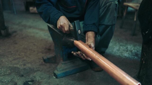 Traditional coppersmith workshop for copper brewing pots manufacturing. This handmade brewery kettles will be used for making traditional alcohol brandy drinks. Small traditional business concept.