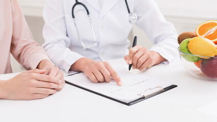 Appointment at dietician's. Woman making diet plan with professional nutritionist in clinic