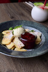 Traditional Austrian Kaiserschmarrn served with sour cherry sauce and a scoop of vanilla ice cream.