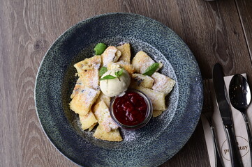 The sweet, fluffy torn pancake is dusted with powdered sugar, offering a warm and comforting appearance with a vibrant dessert backdrop.