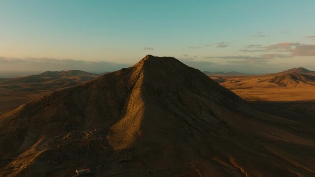 Drone sunset view of Mount Tindaya with golden light on summit, Fuerteventura, Canary Islands