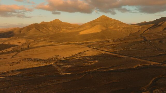 Aerial view of Vallebr&oacute;n mountain ridge in Fuerteventura with dramatic cloudy sky and patchy light from the sun breaking through clouds
