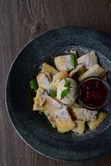 The sweet, fluffy torn pancake is dusted with powdered sugar, offering a warm and comforting appearance with a vibrant dessert backdrop.