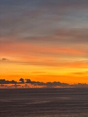 Vertical sunset view over ocean with calm waves and vibrant sky in Bali island, Indonesia. Beautiful beach landscape, travel, nature, seascape, summer, vacation, relaxation photo