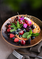A plate of French toast topped with fresh berries and whipped cream, served as a delicious and visually appealing brunch. Homemade sweet breakfast captured in natural lighting with cozy styling