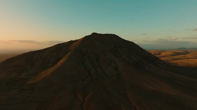 Drone sunset view of Mount Tindaya with golden light on summit, Fuerteventura, Canary Islands