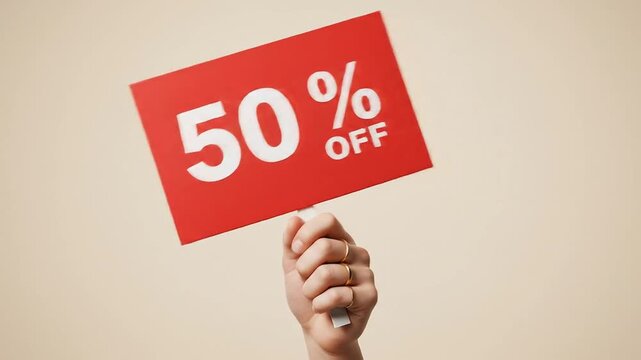Hand holding a red sign advertising a 50% discount.