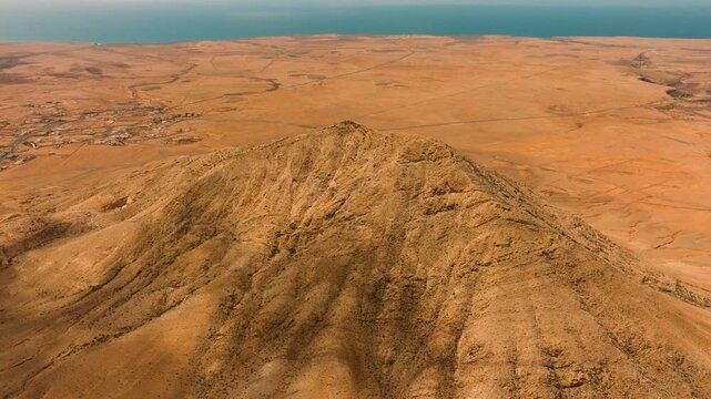 Aerial view of Mount Tindaya under midday sun with clouds casting shadows, Fuerteventura, Canary Islands
