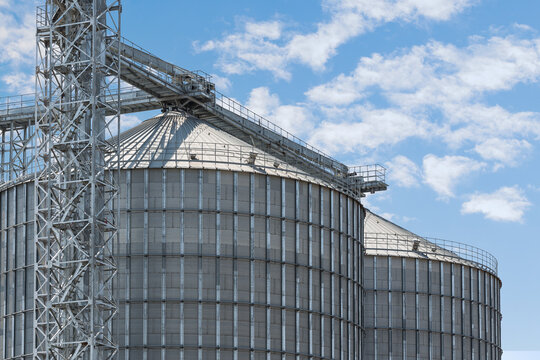 Agricultural Silos - Building Exterior, Storage and drying of grains, wheat, corn, soy, sunflower against the blue sky.