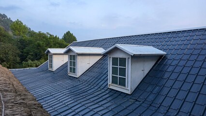 A house with a slanted roof and a window on the top
