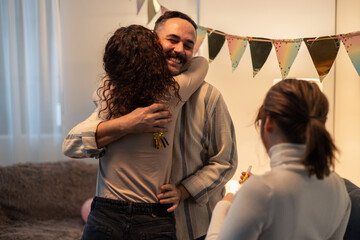 Friends embracing at birthday party with decorations and balloons
