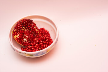 Organic Sweet Red Pomegranate in Bowl on White Background