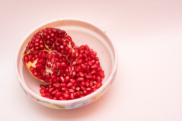 Organic Sweet Red Pomegranate in Bowl on White Background