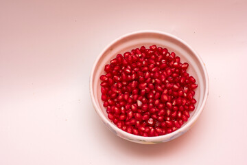 Organic Sweet Red Pomegranate in Bowl on White Background
