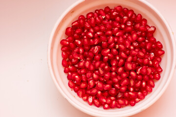 Organic Sweet Red Pomegranate in Bowl on White Background