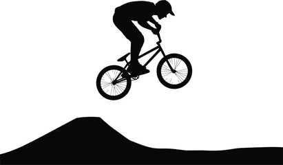 Fototapeta premium Dynamic silhouette of a bmx rider performing a jump over a dirt ramp in mid air action