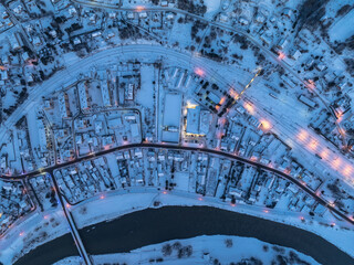 Lot nad centrum Muszyny wieczorem zimą.