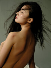 Profile of a woman with flowing hair against a muted background.
