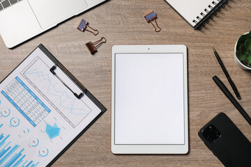 Tablet, smartphone, different stationery and laptop on wooden table, flat lay