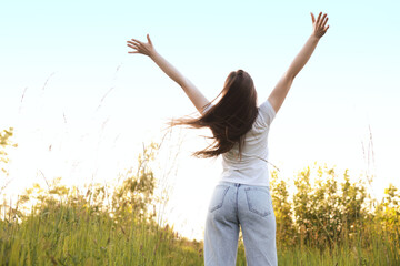 Feeling freedom. Woman enjoying time in nature, back view