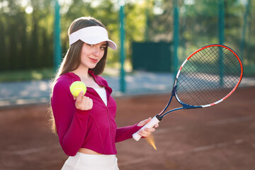 Beautiful woman with racket and ball at tennis court