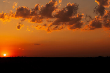 Colorful Sunset Sky Over Nature Landscape with Silhouetted Trees and Clouds