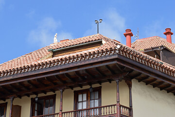 Facade of Modern Building with Balcony Chimneys and Sculpture on Roof with Sun Terrace and Terra Cotta Tiles 