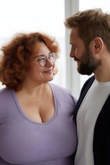 Fototapeta premium Happy caucasian couple smiling at each other in cozy setting