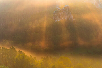 The Bastei rock formation in Saxon Switzerland at sunrise with fog in the background. A well-known tourist destination in Germany with viewing platforms.