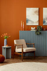 Playful contrast of tulips and abstract mock up art against a warm orange wall. Modern retro interior and design decor.
