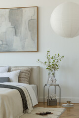 Bright bedroom corner with neutral palette, geometric pillow and fresh florals. Soft natural styling.