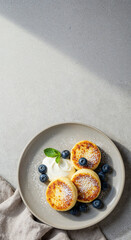  Syrniki with Blueberries and Sour Cream on Grey Plate