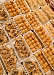 an assortment of cookies on plastic packages under a film in a store or bakery. a variety of delicious cookies in the supermarket are divided into weight portions.