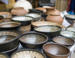 Fototapeta premium Handmade pottery is sold on the street. Colorful ceramic plates and bowls. 