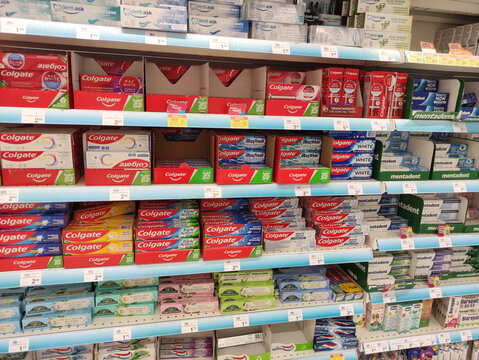 Rome, Italy - July 23, 2025: Colgate toothpaste products neatly arranged on supermarket shelves, showcasing various flavors and packaging designs in a vibrant retail environment
