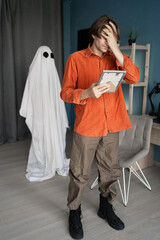 Concept of afterlife and memory of lost love. Widower man cries looking at old photo ghost of wife...