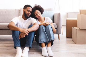 Eviction From Apartment. Frustrated African Couple Sitting Among Moving Boxes Having Problems With House Rental Indoors. Real Estate, Mortgage And Renting Issues Concept. Free Space