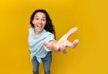 Give Me This. Young lady outstretching hand, trying to grab or hold something invisible on her open...