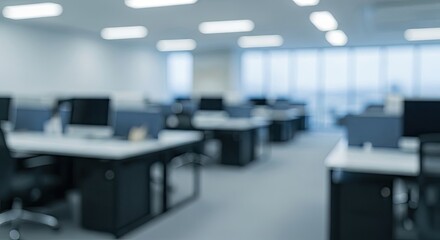 Modern office interior with rows of desks and computers, creating a professional workspace atmosphere bathed in natural light.