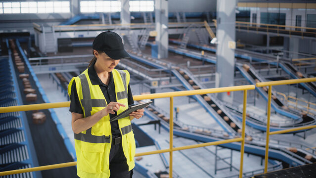 Female Delivery Specialists working in the Automated Facility and Using Digital Tablet Computer