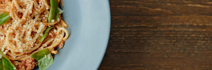 Header showing plate with spaghetti pasta topped with grated cheese, ground meat, and fresh basil...