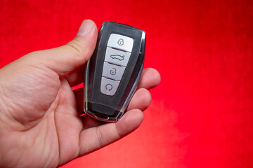 man holding a remote car key on red