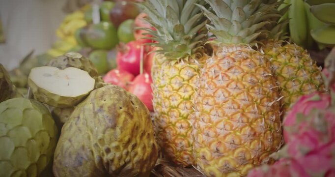 Close-up of fresh pineapple and vibrant dragon fruit at the Lavradores Market on Madeira Island