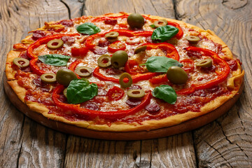 Delicious pizza served on wooden plate